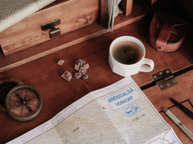 Carte ancienne de musées français sur une table en bois avec une boussole en laiton
