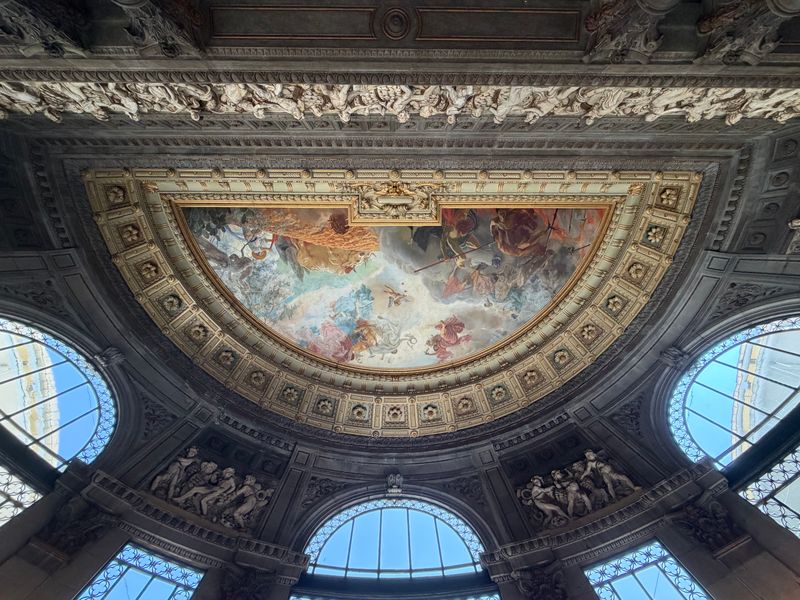Vue d’une salle de musée parisien avec visiteurs, éclairage naturel et architecture classique