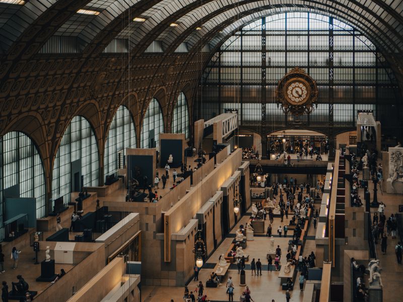 Salle du musée d'Orsay avec son horloge monumentale et des visiteurs admirant les sculptures